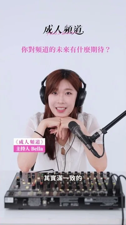 主持人 Bella 戴著耳機、手托著下巴坐在麥克風前受訪